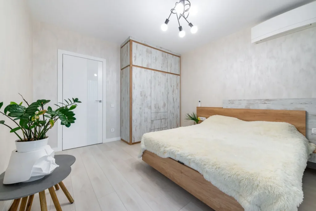 A HEPA air purifier running on a nightstand next to a bed