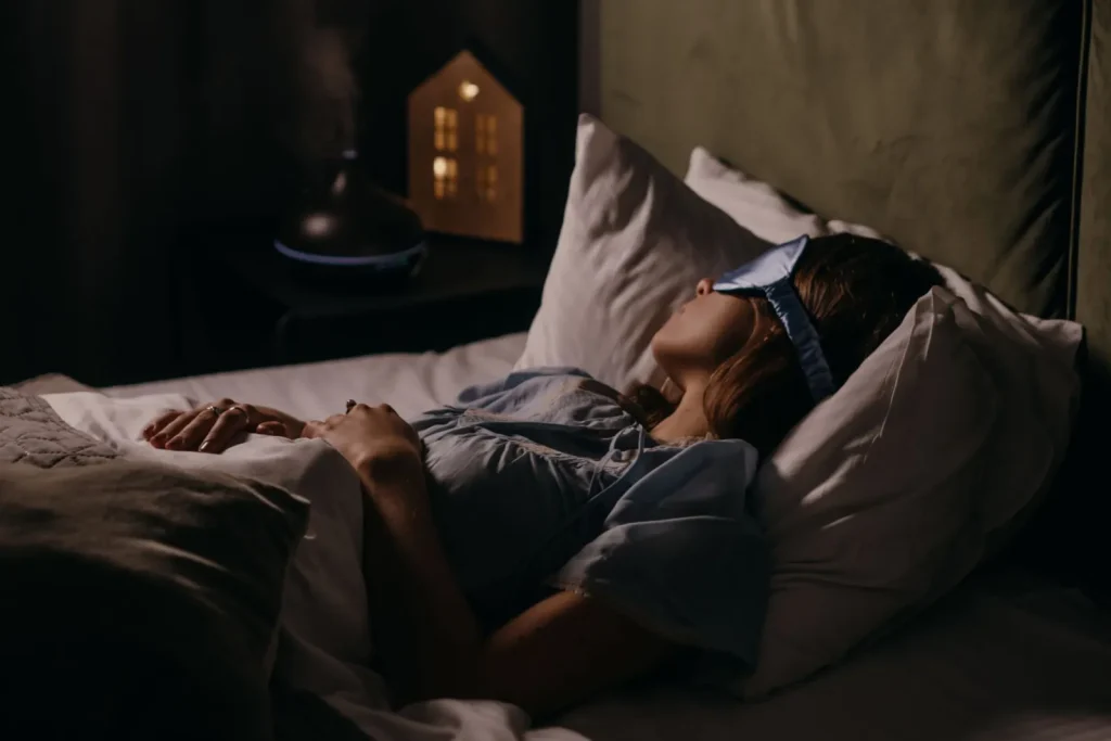 A compact cool-mist humidifier running on the floor a few feet from a bed
