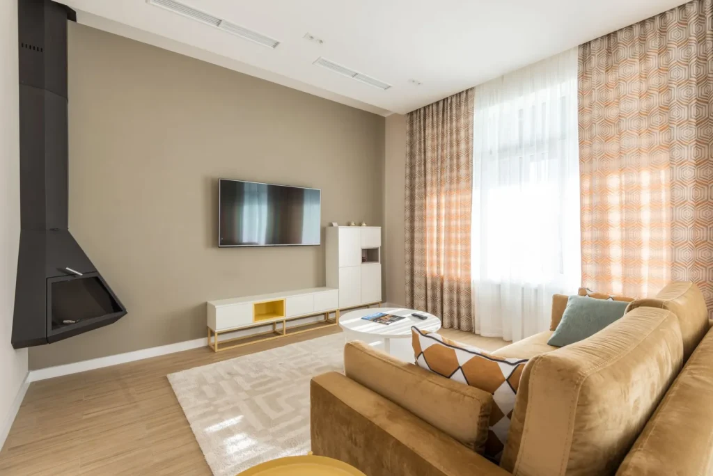 A digital hygrometer mounted at eye level on an interior living room wall away from windows