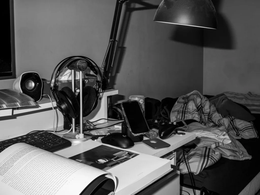 A tabletop CO2 monitor on a bedroom nightstand showing a parts-per-million reading