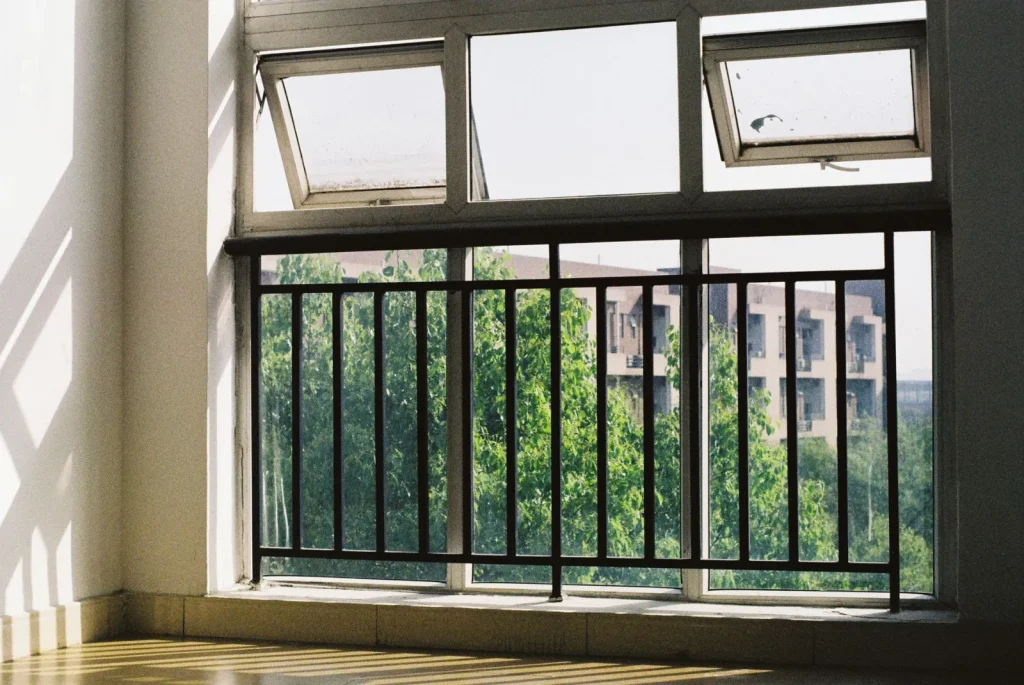 A cracked-open window ventilating a room to lower indoor carbon dioxide levels