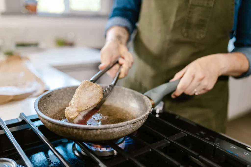 Cooking on a gas stove releasing fine particles and combustion gases into a home kitchen