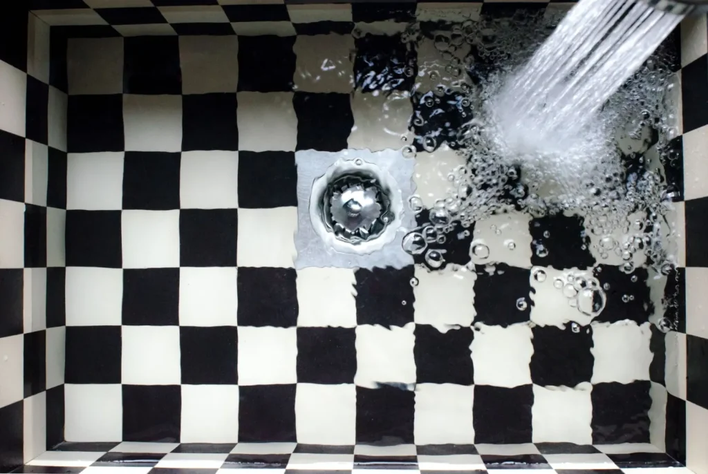 A dehumidifier raised on blocks with a gravity drain hose running to a floor drain