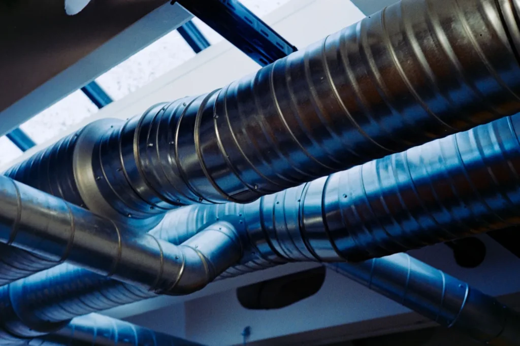 An ERV unit mounted in a basement with insulated supply and exhaust ducts connected