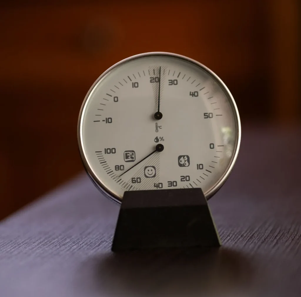 A digital hygrometer on a shelf showing 45 percent relative humidity across a living room