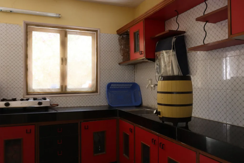 A HEPA air purifier placed at the edge of an open kitchen a few feet from the stove