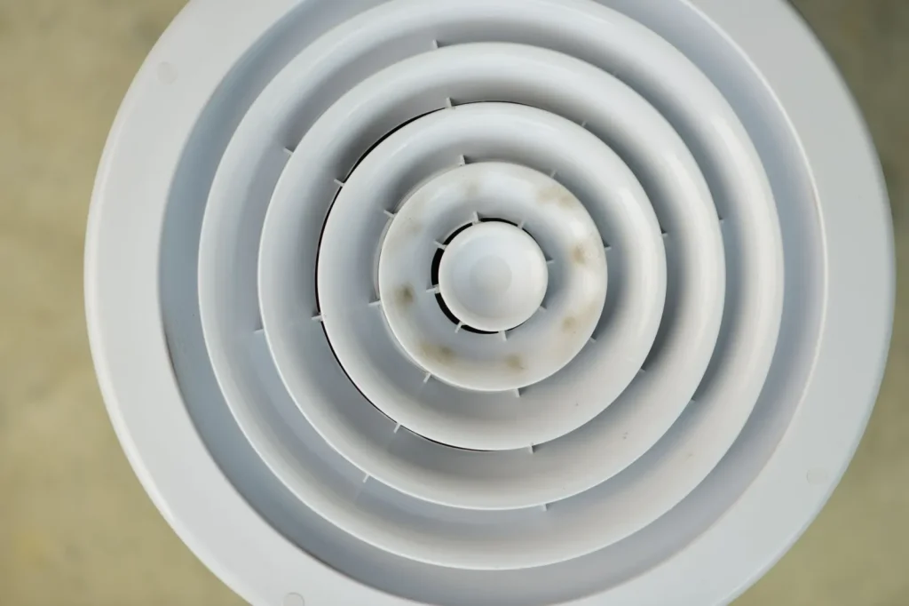 A manual humidistat dial mounted on a home furnace duct, showing a percentage scale
