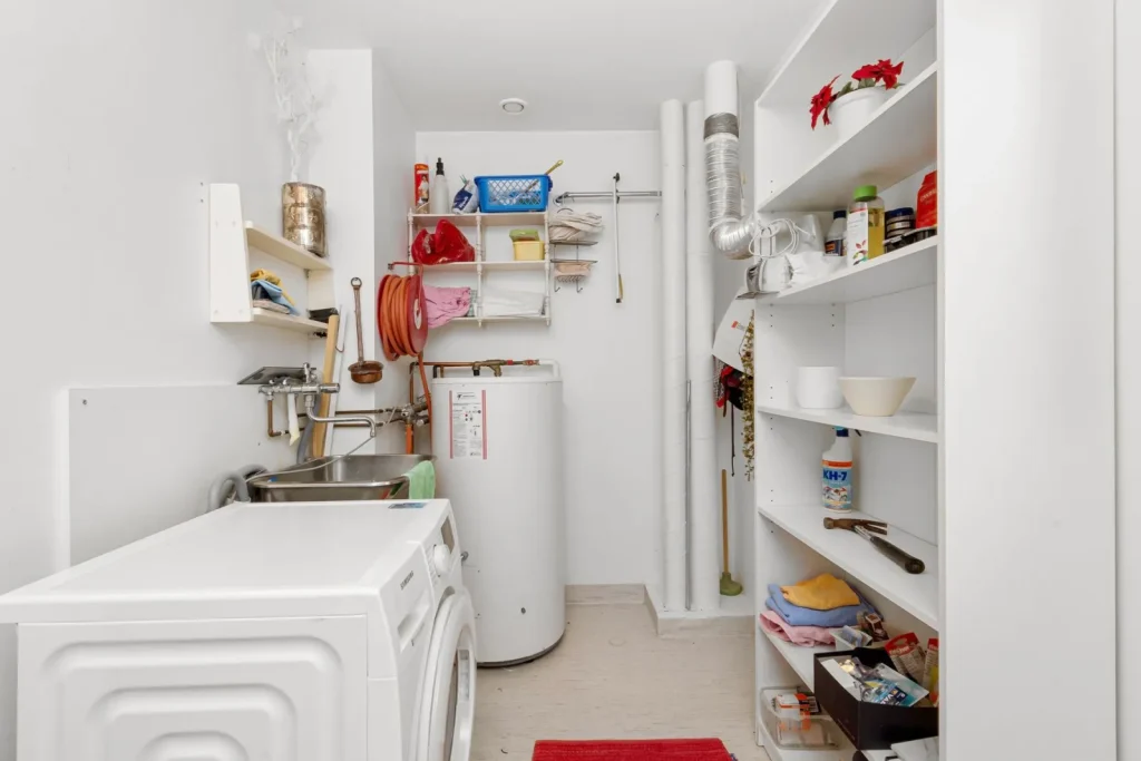 A portable dehumidifier running in a finished basement with its water tank partly full
