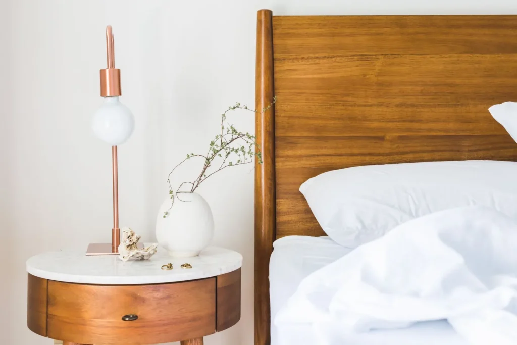 A portable cool-mist humidifier running on a bedroom nightstand with visible mist
