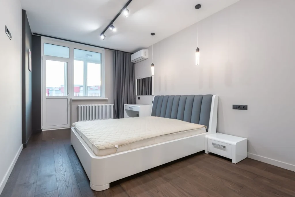 A compact air purifier running on a nightstand in a small bedroom