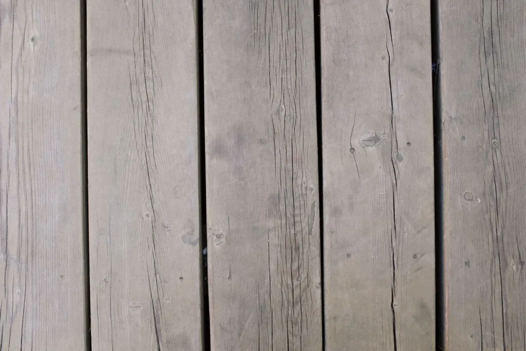Close-up of thin seasonal gaps between oak hardwood floor planks in a dry winter room