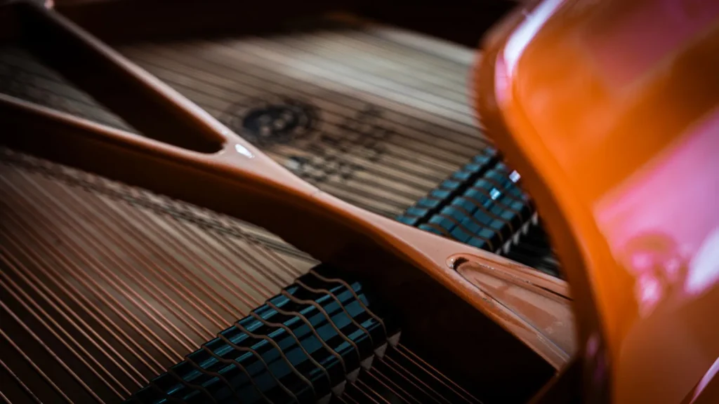 Interior view of a grand piano soundboard showing the spruce panel and ribs that react to humidity