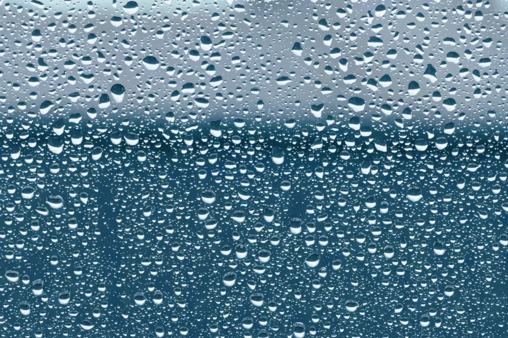 Condensation forming on the inside of a cold window, a sign of high indoor humidity