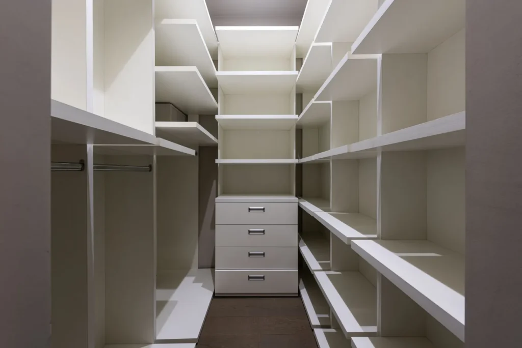 A rechargeable silica gel dehumidifier puck sitting on a closet shelf beside folded linens