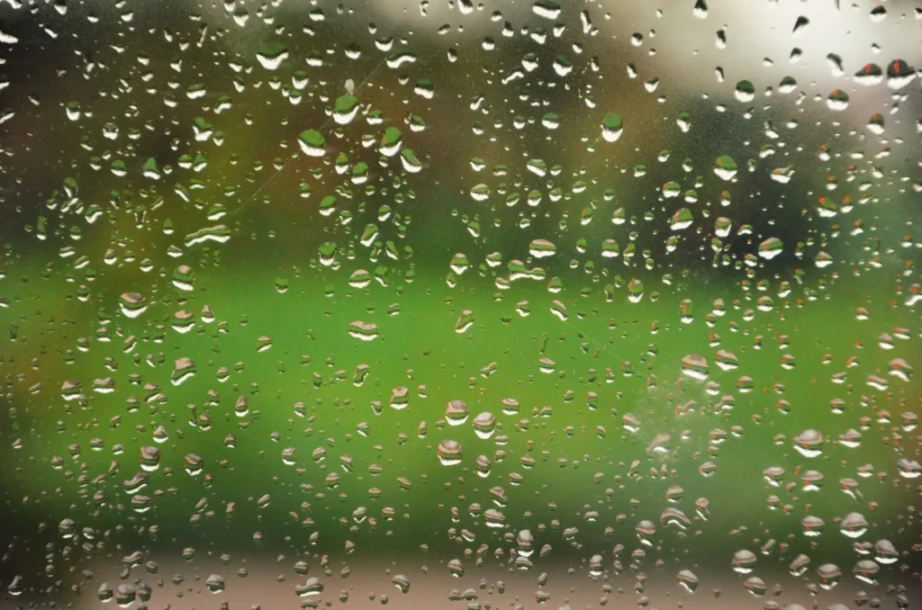 Heavy condensation and water droplets running down a cold window pane, a sign of too much indoor humidity