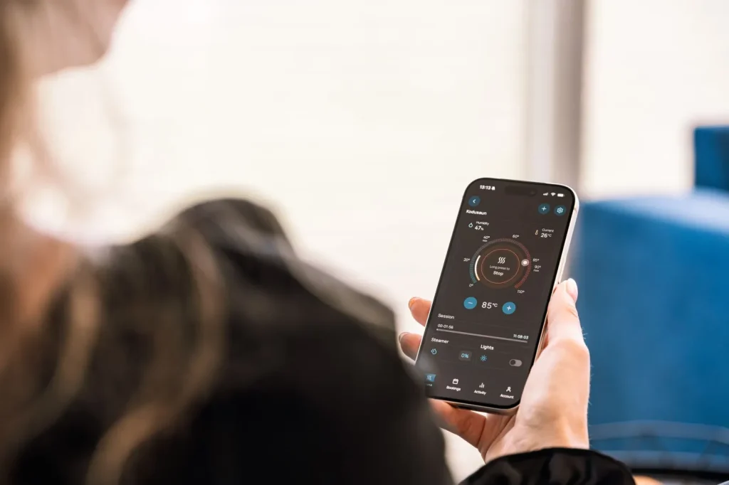 A smart humidifier running in a bedroom with a phone app showing the humidity level