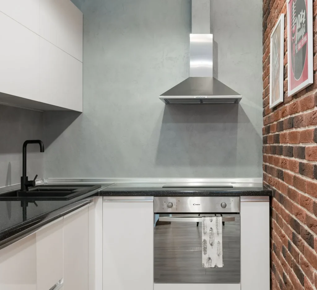 A stainless steel range hood mounted over a kitchen cooktop