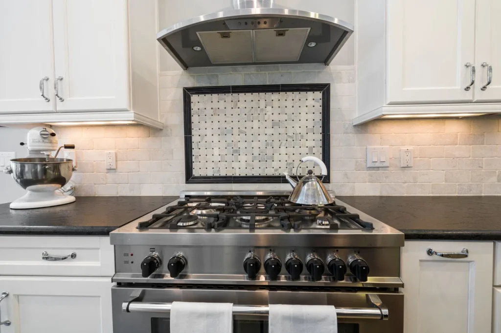 Hands replacing a round charcoal filter inside a recirculating range hood