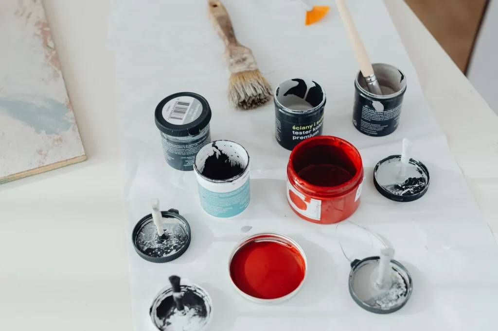 An open can of paint with a brush, a common indoor source of VOCs