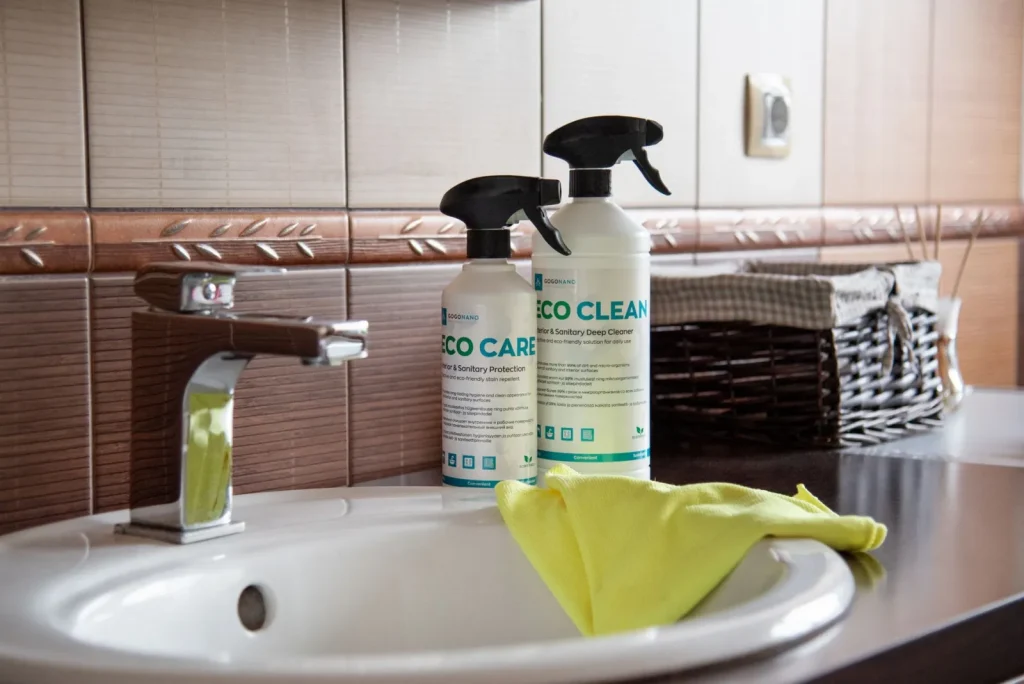 Household cleaning spray bottles stored under a kitchen sink
