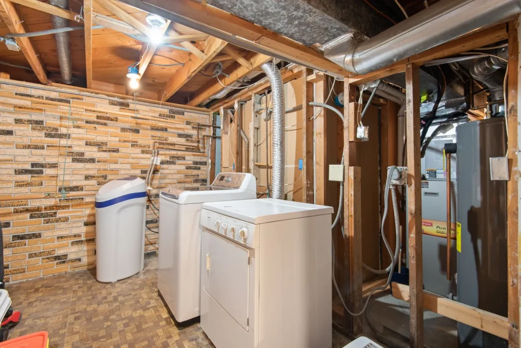 A wall-mounted heat recovery ventilator connected to ductwork in a home basement