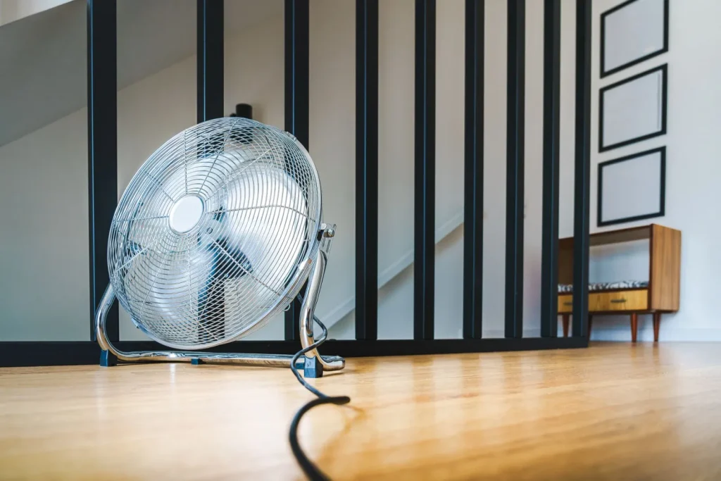 A portable dehumidifier sitting in an open basement space with clear room around it for airflow