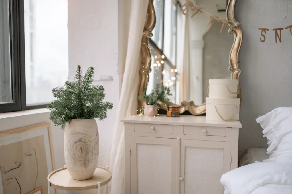 A cool mist humidifier raised on a bedroom dresser, several feet from the wall and bed