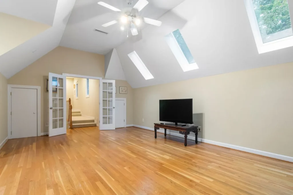 A large whole-house fan mounted in a hallway ceiling with louvers open