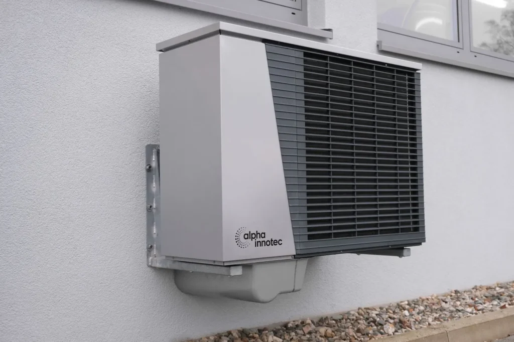 A wall-mounted HRV unit with two insulated duct connections in a basement